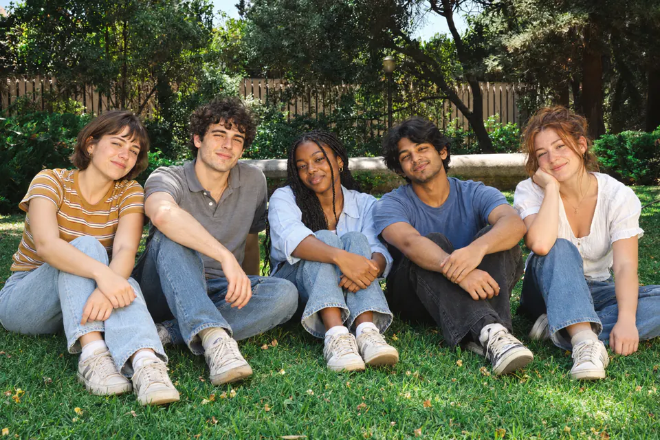 Five creators sitting together on the grass