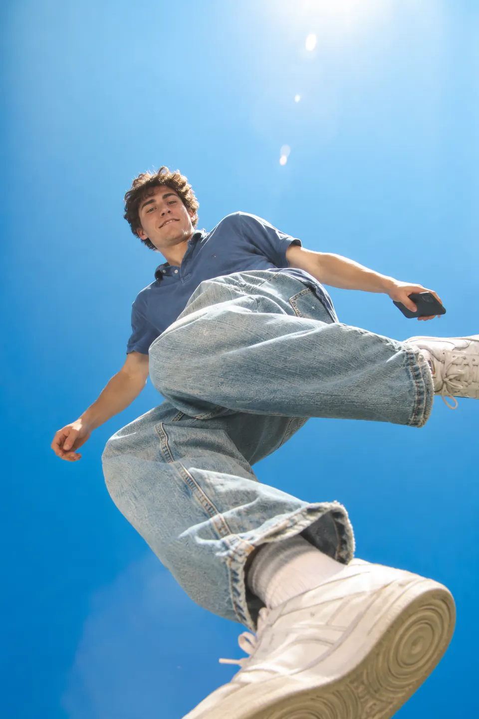 Creator leaping over the camera against a bright blue sky